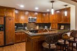Gourmet fully equipped kitchen with formal dining table and bar seating 